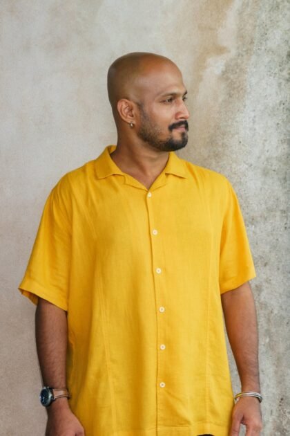 Man in yellow shirt looking sideways