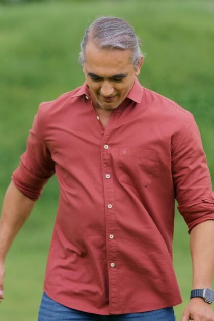 Man looking down in deep red shirt