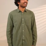 Man in olive green shirt looking sideways.