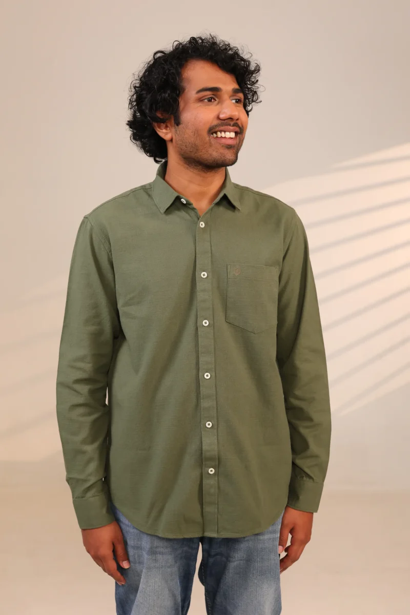 Man in olive green shirt looking sideways.