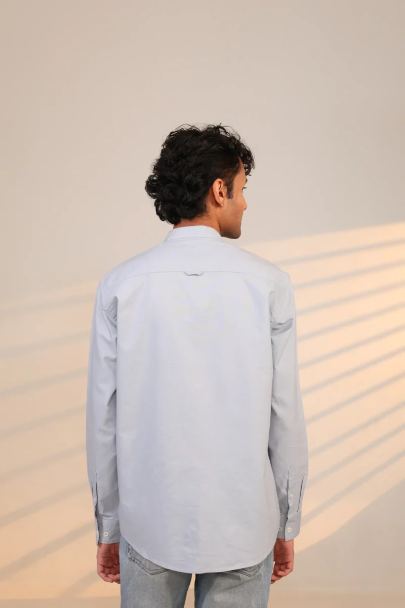 Rear view of light blue shirt with soft creases.