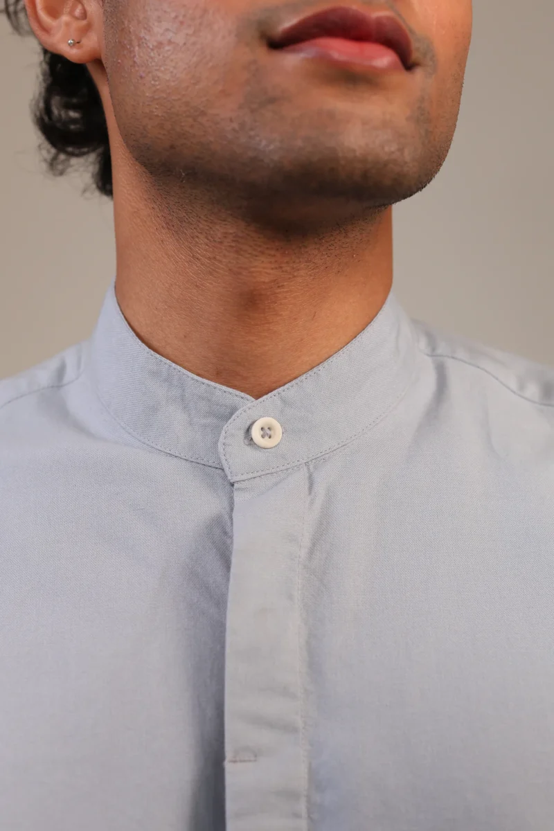 Close-up of mandarin collar with button fastened.