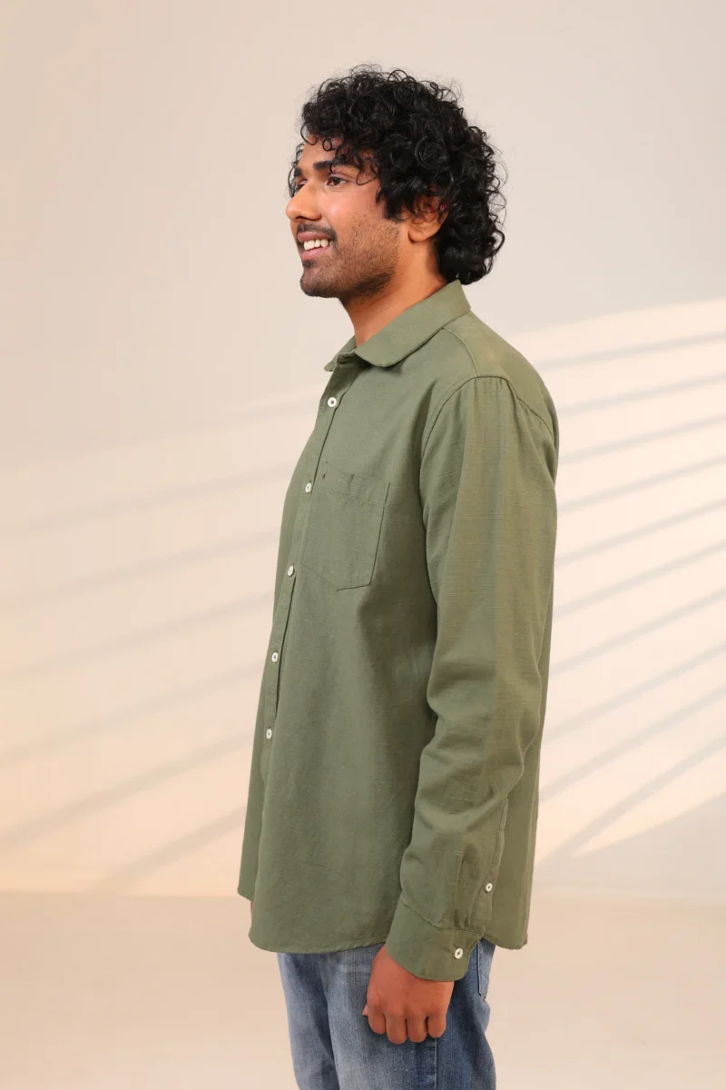 Man in olive green shirt side profile facing left.