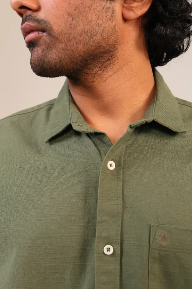 Close-up of olive green shirt collar and chest.