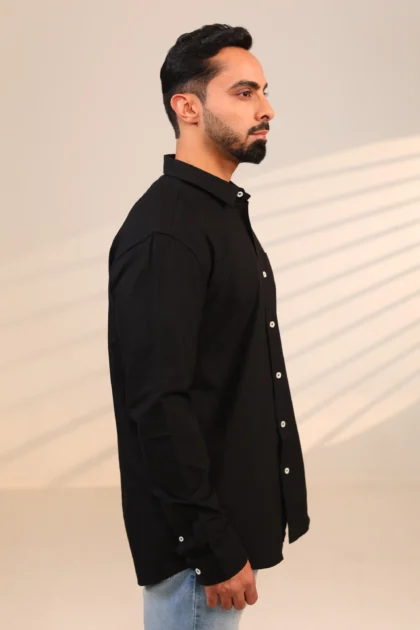 Side view of black shirt with man standing straight.