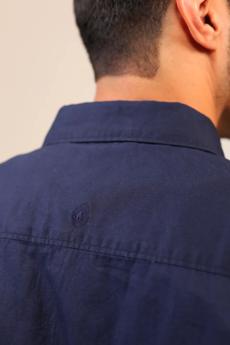 Close-up of navy shirt collar and neck stitching.