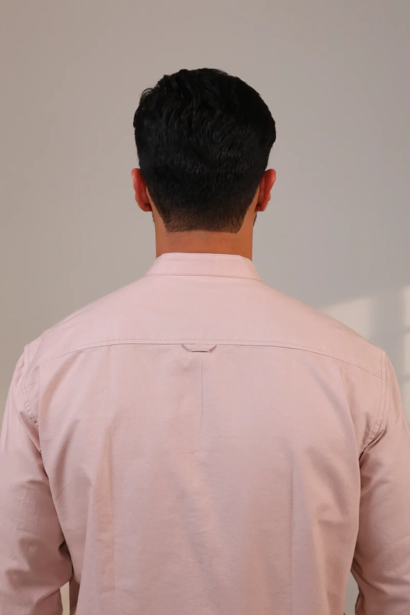 Close-up of textured pink shirt fabric from the back.